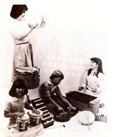 A group of children using an Omnichord with percussion and classroom instruments.